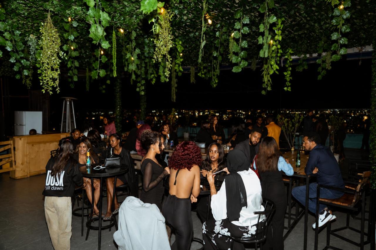 AASC members socializing at a rooftop lounge overlooking the Addis Ababa skyline at night